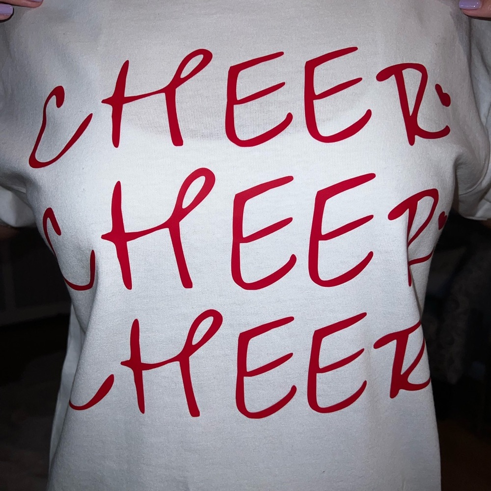 Cheerleading T-Shirt. It is white with red writing (size: medium).